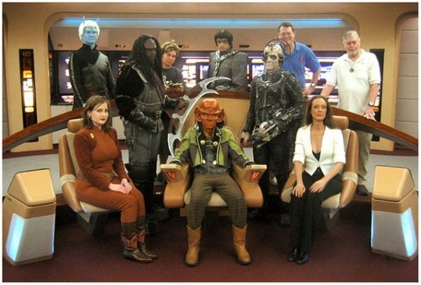 Image of Star Trek the experience cast and crew hanging out on the Bridge of the 1701-D