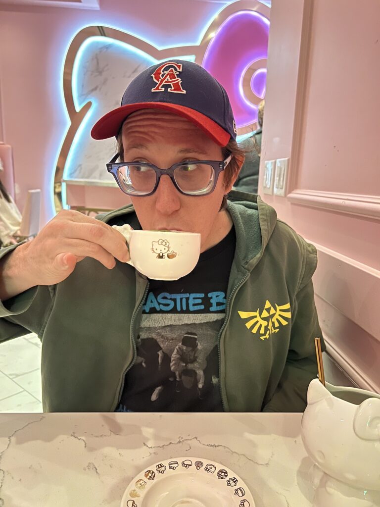 Derick McDuff candid photo, drinking a hot beverage from a chine cup